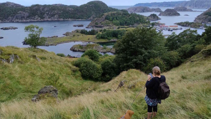 Gesche steht auf dem Berg mit der Nazi-Festung auf der Insel Hidra. Man erkennt, dass es hinter ihr steil bergab geht. Die Aussicht auf den Fjord ist atemberaubend.