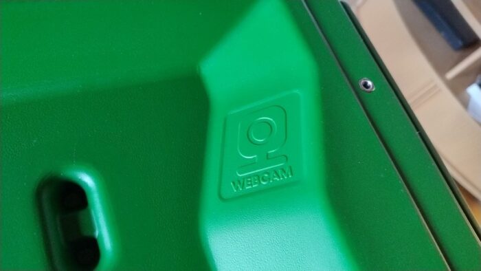 Grünes Plastik-Bauteil unseres Hühnerstalls. Zu sehen ist ein Symbol für eine Webcam, das auch mit