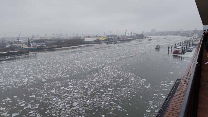 Blick von der Plaza der Elbphilharmonie auf die Elbe. Auf dem Wasser treiben tausende Eisschollen. Das Wetter ist diesig und grau.