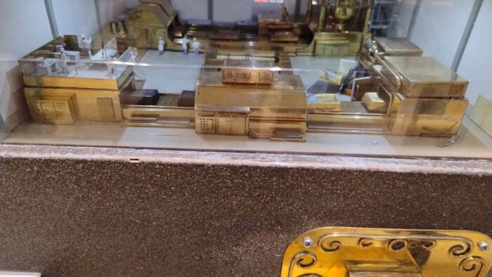 Nahaufnahme der "Schokoladenfabrik" im Miniaturwunderland: Kleine "Maschinen" transportieren scheinbar Schokoladentäfelchen und verpacken sie. Rechts unten ist im Anschnitt der messingfarbene Ausgabeschacht zu erkennen.