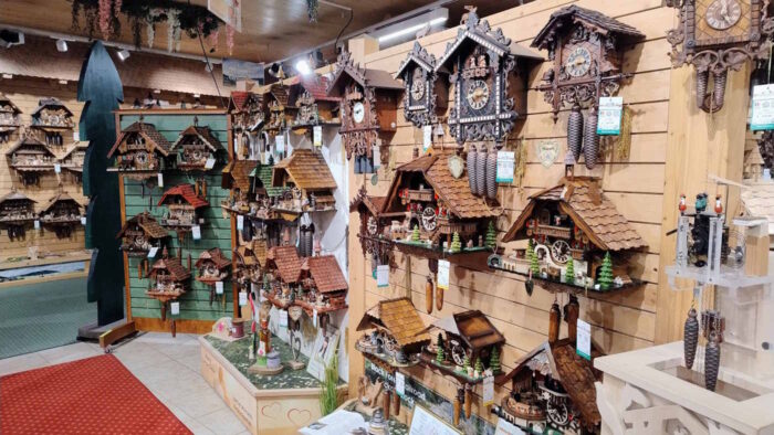 Eine Wand in einem Laden. Sie hängt voller Kuckucksuhren.